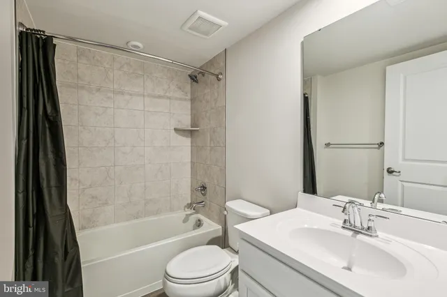 a bathroom with a bathtub shower sink vanity and toilet