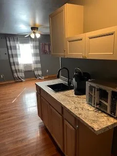 a kitchen with stainless steel appliances granite countertop a sink a stove and a wooden floors