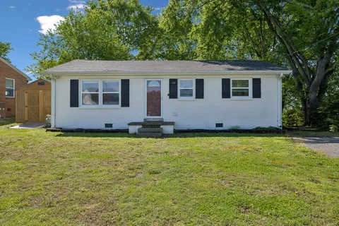a front view of house with yard and trees