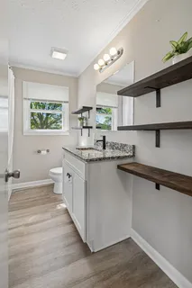 a kitchen with stainless steel appliances granite countertop a sink cabinets and wooden floor