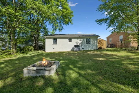 a view of a backyard with a garden and tree