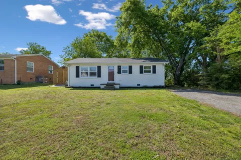 a front view of house with yard and trees around