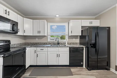a kitchen with stainless steel appliances granite countertop a refrigerator stove and sink