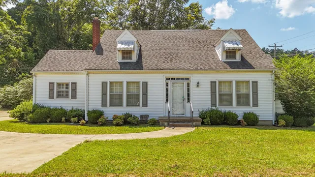 a view of a house with a yard and potted plants