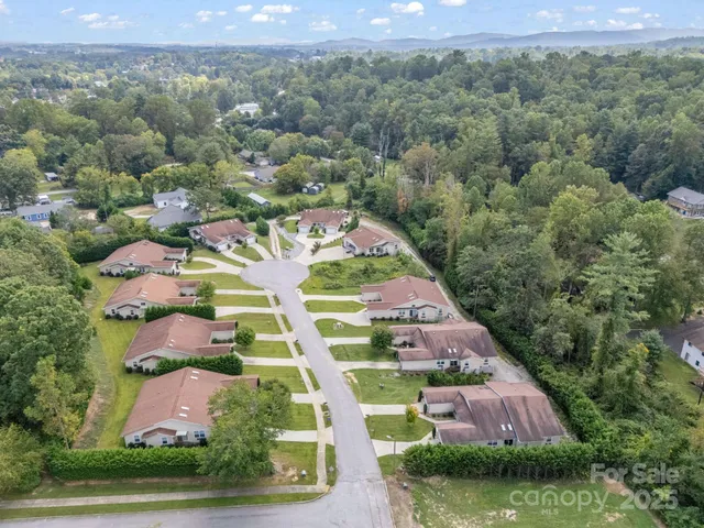 an aerial view of residential houses with outdoor space and parking