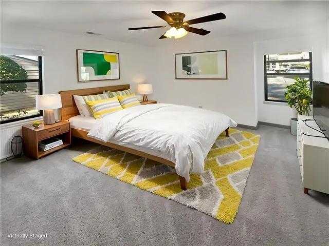 an empty room with windows and fan