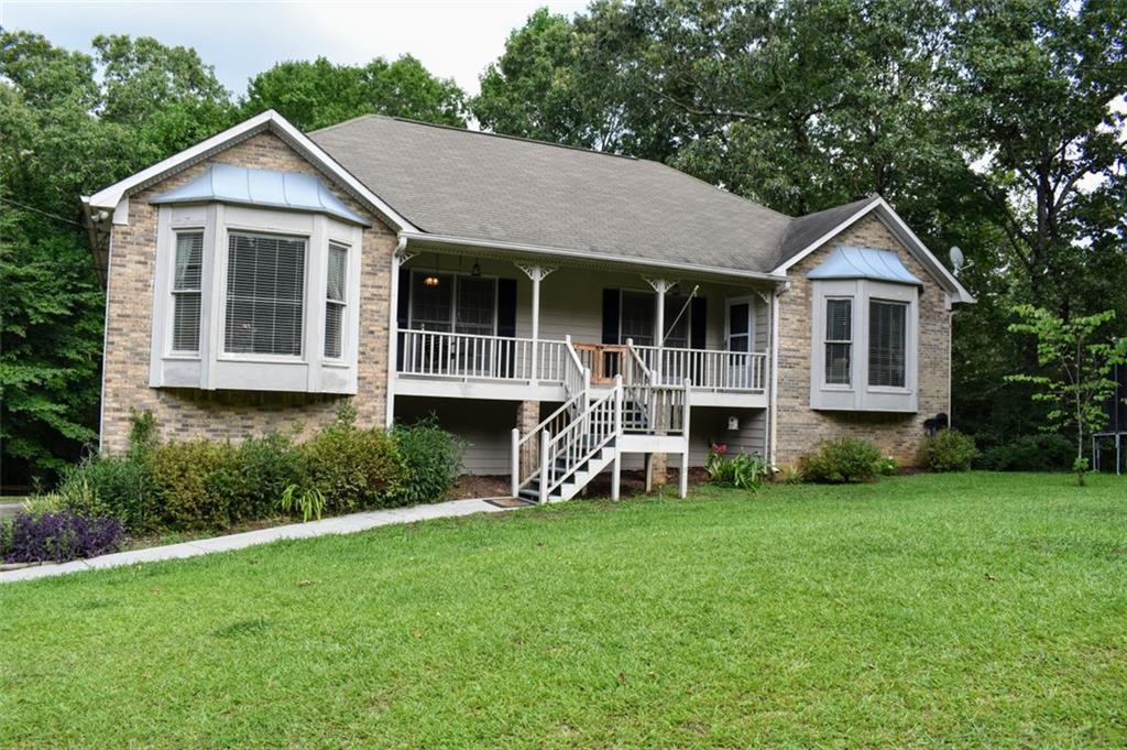 a view of a house with a yard and sitting area