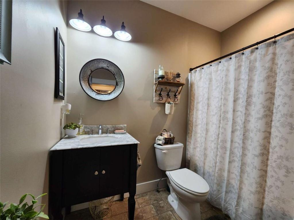 7350 Banks Mill Road Douglasville, GA 30135 - Photo 12 of 27 a bathroom with a toilet sink vanity and mirror