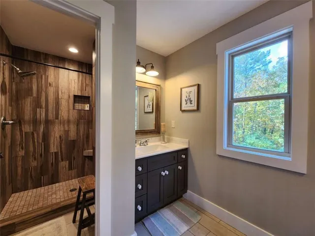 a bathroom with a double vanity sink a mirror and a shower