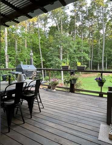 7350 Banks Mill Road Douglasville, GA 30135 - Photo 26 of 27 a view of a patio with table and chairs and wooden floor