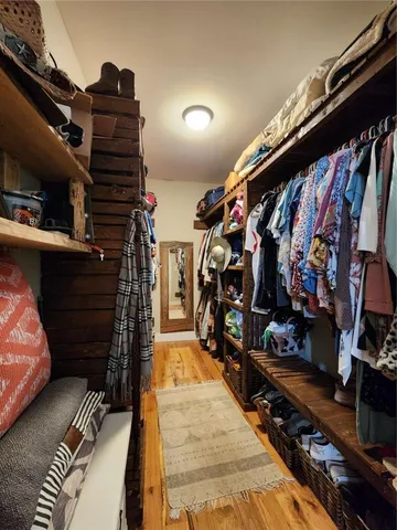 a view of walk in closet with clothes and shoes
