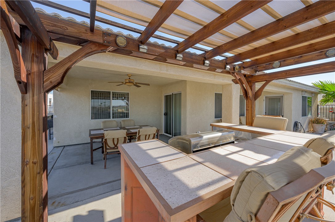 4406 Mercer Road Bullhead City, AZ 86429 - Photo 53 of 92 View of patio / terrace with outdoor dining space, an outdoor hangout area, ceiling fan, area for grilling, and a pergola