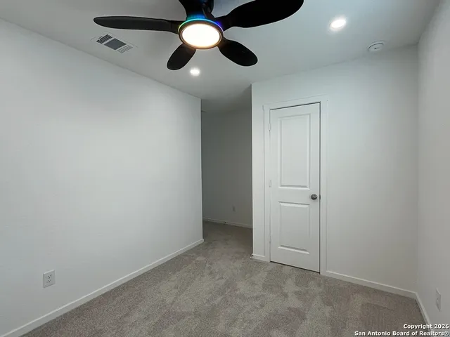 an empty room with a ceiling fan and fan