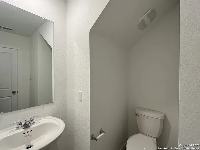a bathroom with a toilet a sink and mirror