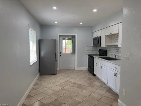 a kitchen with stainless steel appliances granite countertop a refrigerator and a stove top oven
