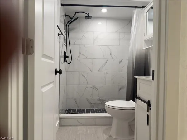 a bathroom with a toilet and a shower