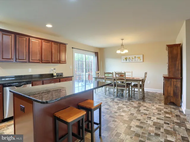 a kitchen with a dining table chairs and refrigerator
