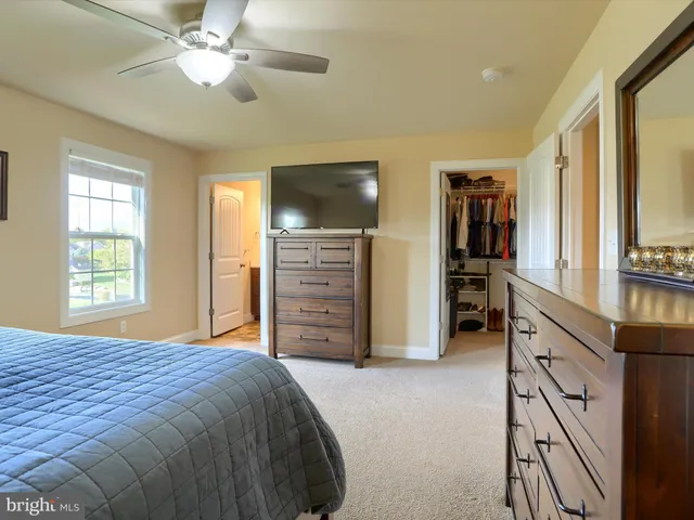 a spacious bedroom with a bed and a flat screen tv