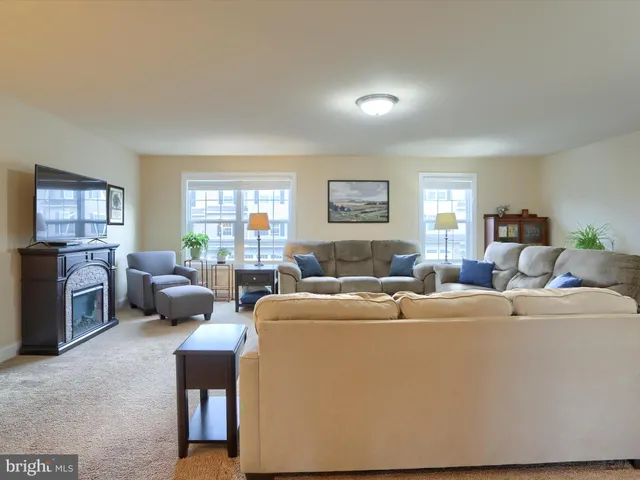 a living room with furniture a large window and a table