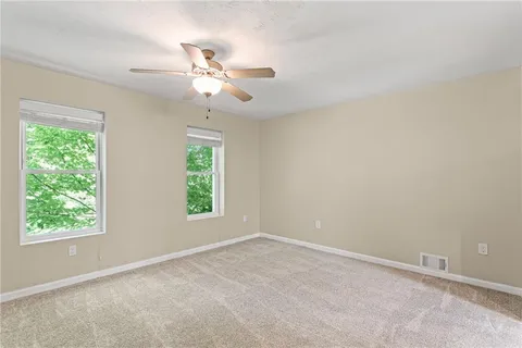 an empty room with a window and a fan