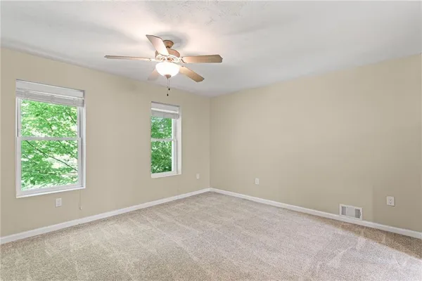 an empty room with a window and a fan
