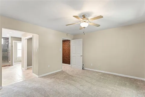 an empty room with closet and fan