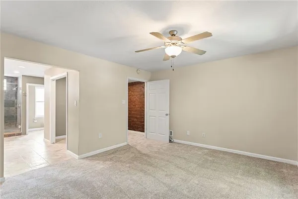 an empty room with closet and fan
