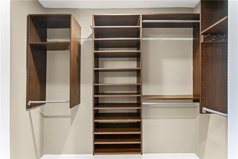 a view of walk in closet with empty racks