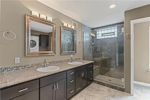 a bathroom with a sink shower and a mirror