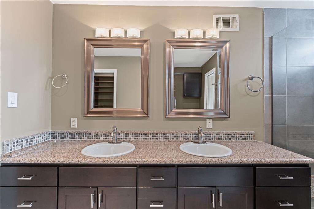 2815 Jane Street Pittsburgh, PA 15203 - Photo 22 of 42 a bathroom with a granite countertop sink a mirror and a shower