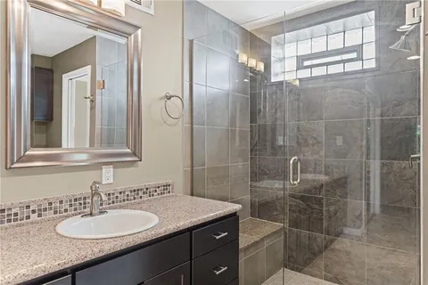 a bathroom with a granite countertop sink a toilet and a mirror