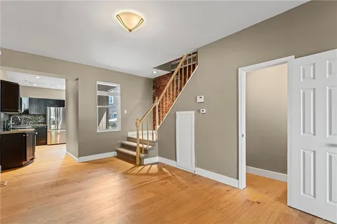 a view of an empty room with a window and wooden floor