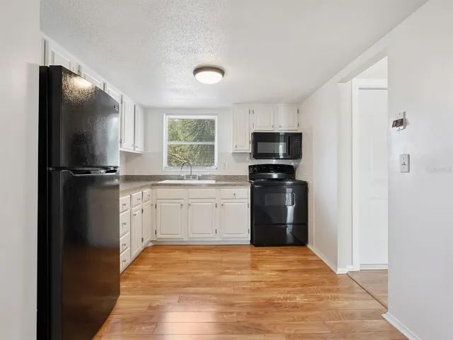 a kitchen with a refrigerator and a stove