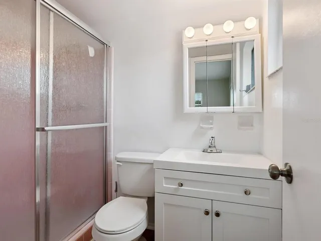 a bathroom with a sink vanity mirror and toilet