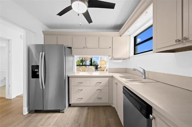a kitchen with a sink cabinets stainless steel appliances and a window
