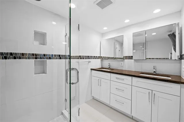 a view of a bathroom with mirror and shower