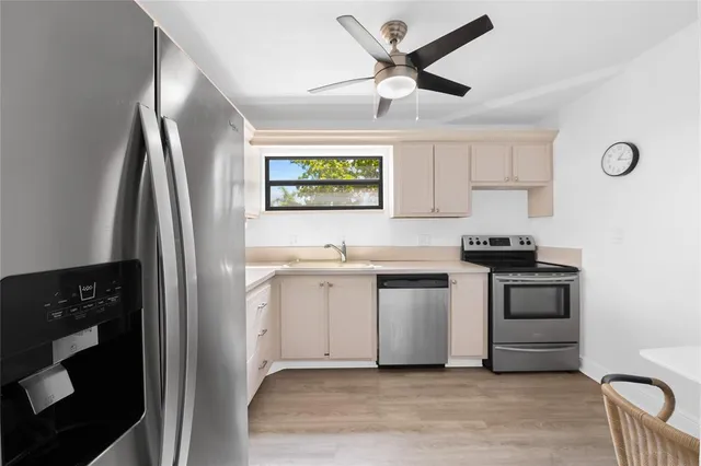 a kitchen with stainless steel appliances white cabinets and a refrigerator