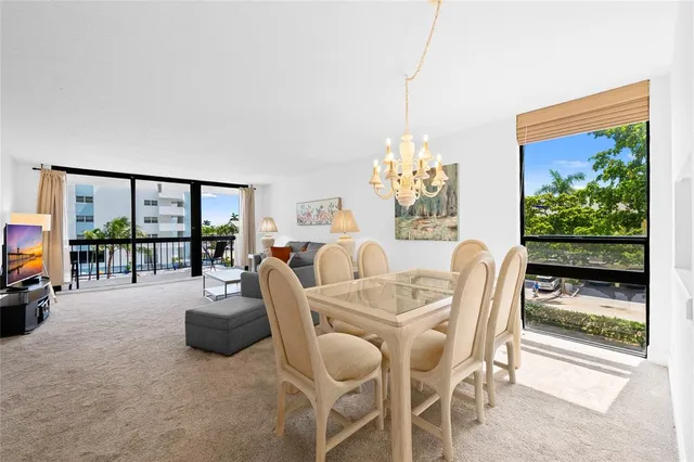 a dining room with furniture and a floor to ceiling window