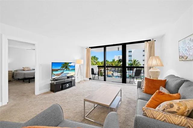 a living room with furniture a large window and a flat screen tv