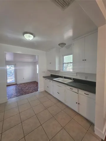 a large kitchen with granite countertop a sink and cabinets