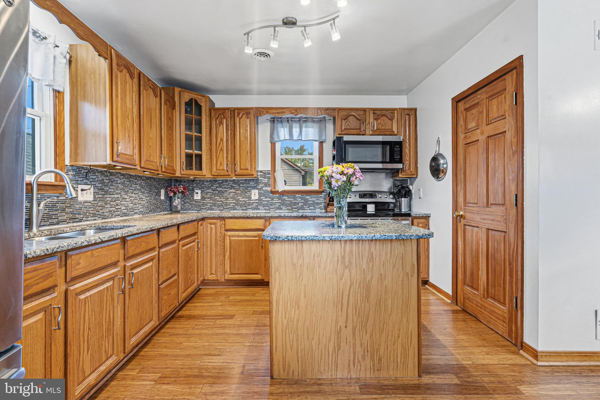 1907 Wills Road Baltimore, MD 21222 - Photo 8 of 42 a kitchen with stainless steel appliances granite countertop a stove top oven a sink dishwasher a refrigerator and cabinets with wooden floor