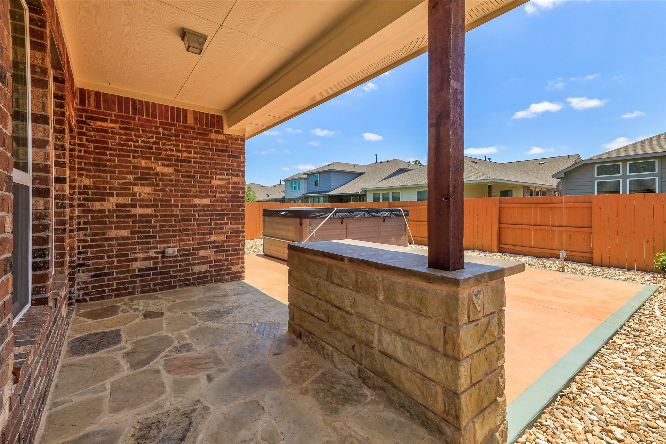 205 Penna Lane Georgetown, TX 78628 - Photo 27 of 32 An inviting stone patio offers a private outdoor retreat, complete with a spa, ideal for relaxation and entertaining.