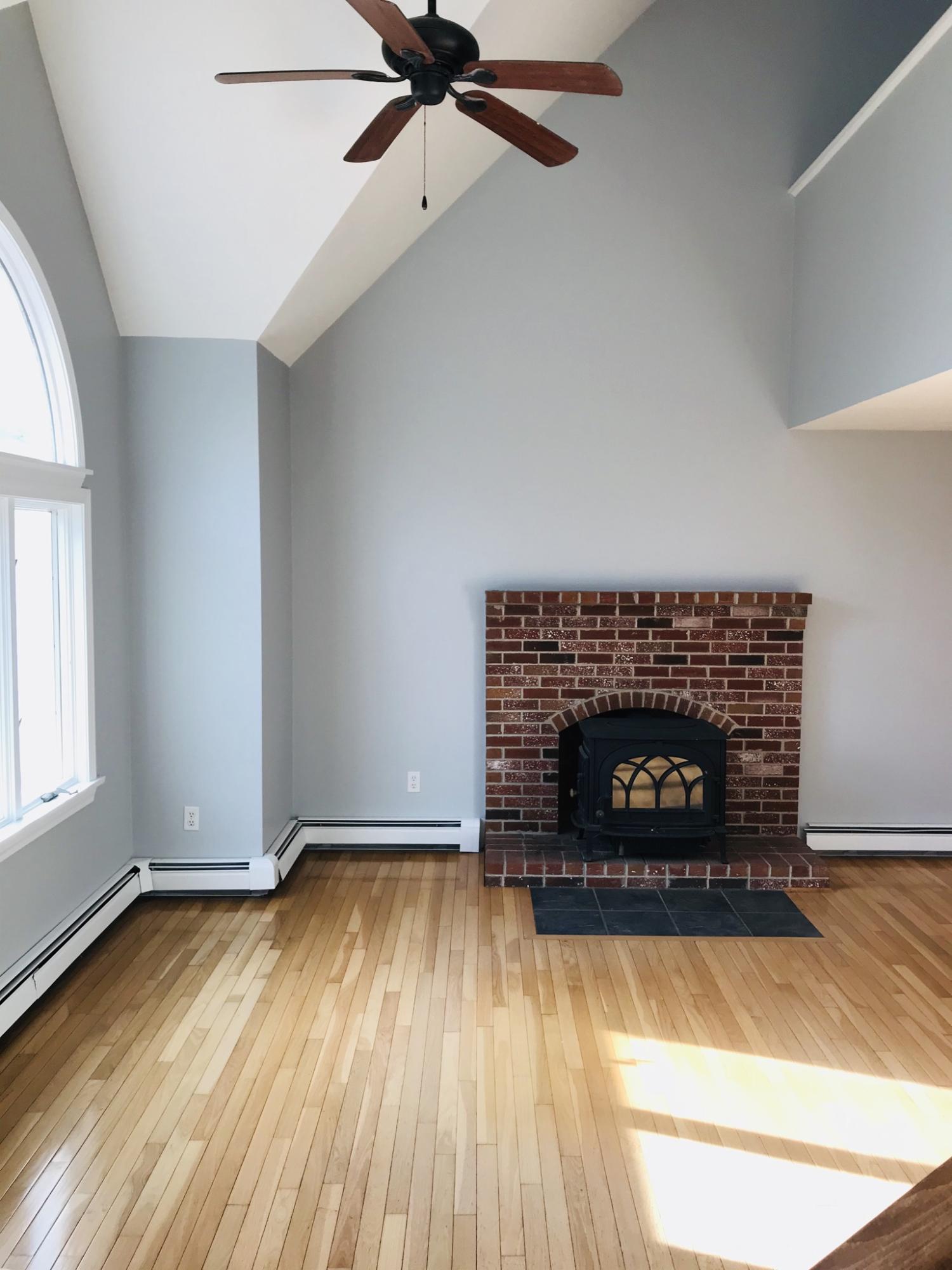 57 Deer Ridge Road Mashpee, MA 02649 - Photo 3 of 18 an empty room with a fireplace and wooden floor