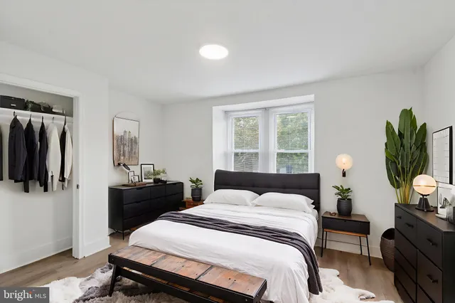 a bedroom with a bed and a potted plant on the table