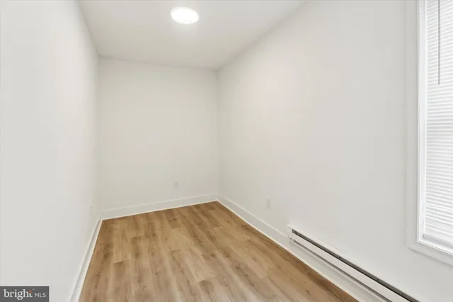 a view of a small space with wooden floor and a window