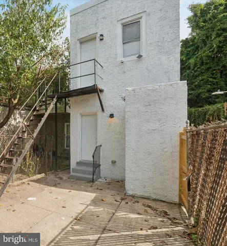 a view of a brick house with a door and wooden fence