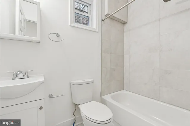 a white toilet sitting next to a white bath tub sitting next to a white sink and a shower