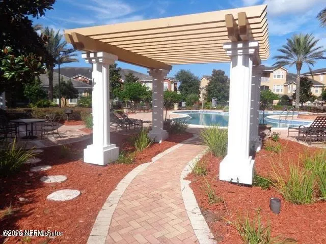 a view of a patio with table and chairs potted plants and floor to ceiling window
