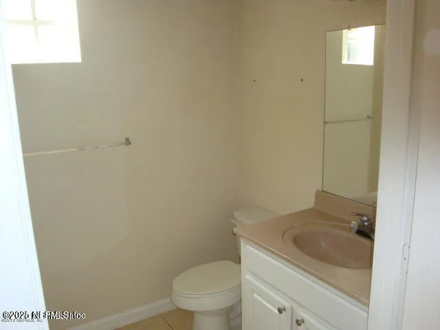 a bathroom with a granite countertop toilet and sink