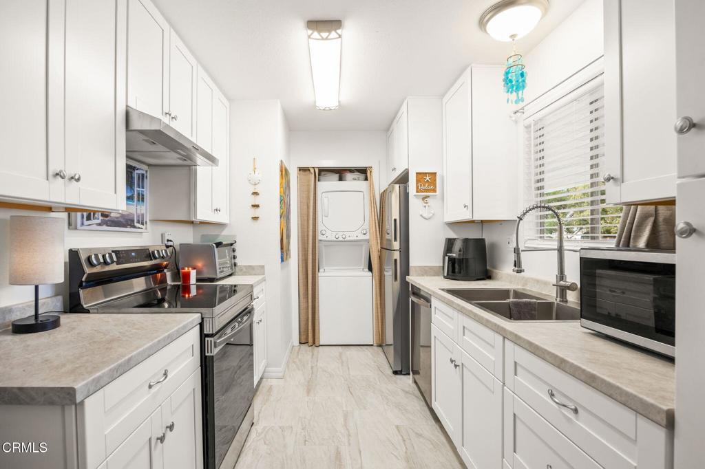 209 South Ventura Road, Unit 18 Port Hueneme, CA 93041 - Photo 15 of 38 a kitchen with stainless steel appliances a refrigerator sink and cabinets
